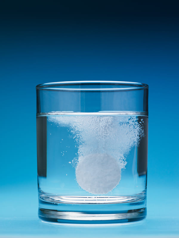 szklanka z wodą i rozpuszczająca się tabletka na kaca